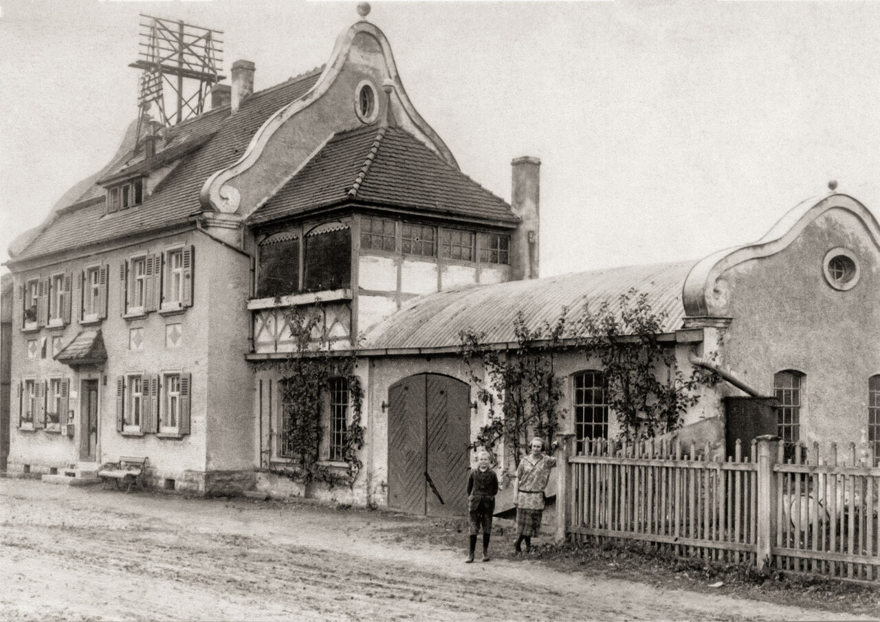 Das Schweifgiebelhaus der Familie Hagen mit einem Dachständer für Telegraphie und Telefon