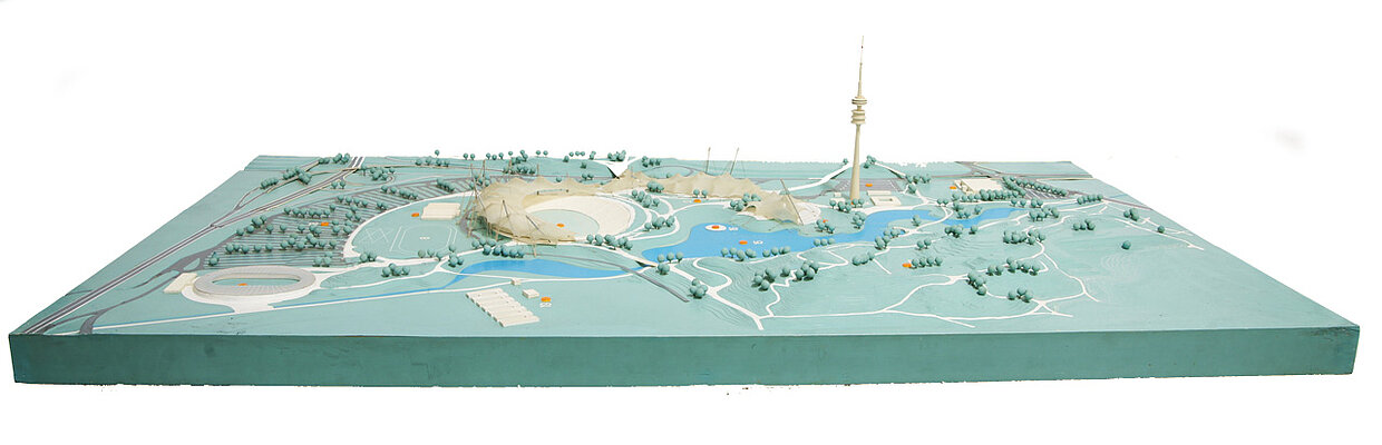 Das Olympiagelände. Seine grüne Lunge, der Olympiapark, wurde von Landschaftsarchitekt Günther Grzimek entworfen. Die offenen Ränder des Parks öffnen ihn zur Stadt hin und beziehen diese ein[5]. Er bietet den Münchnern bis heute hohen Freizeitwert.
Bildnachweis: HdBG
